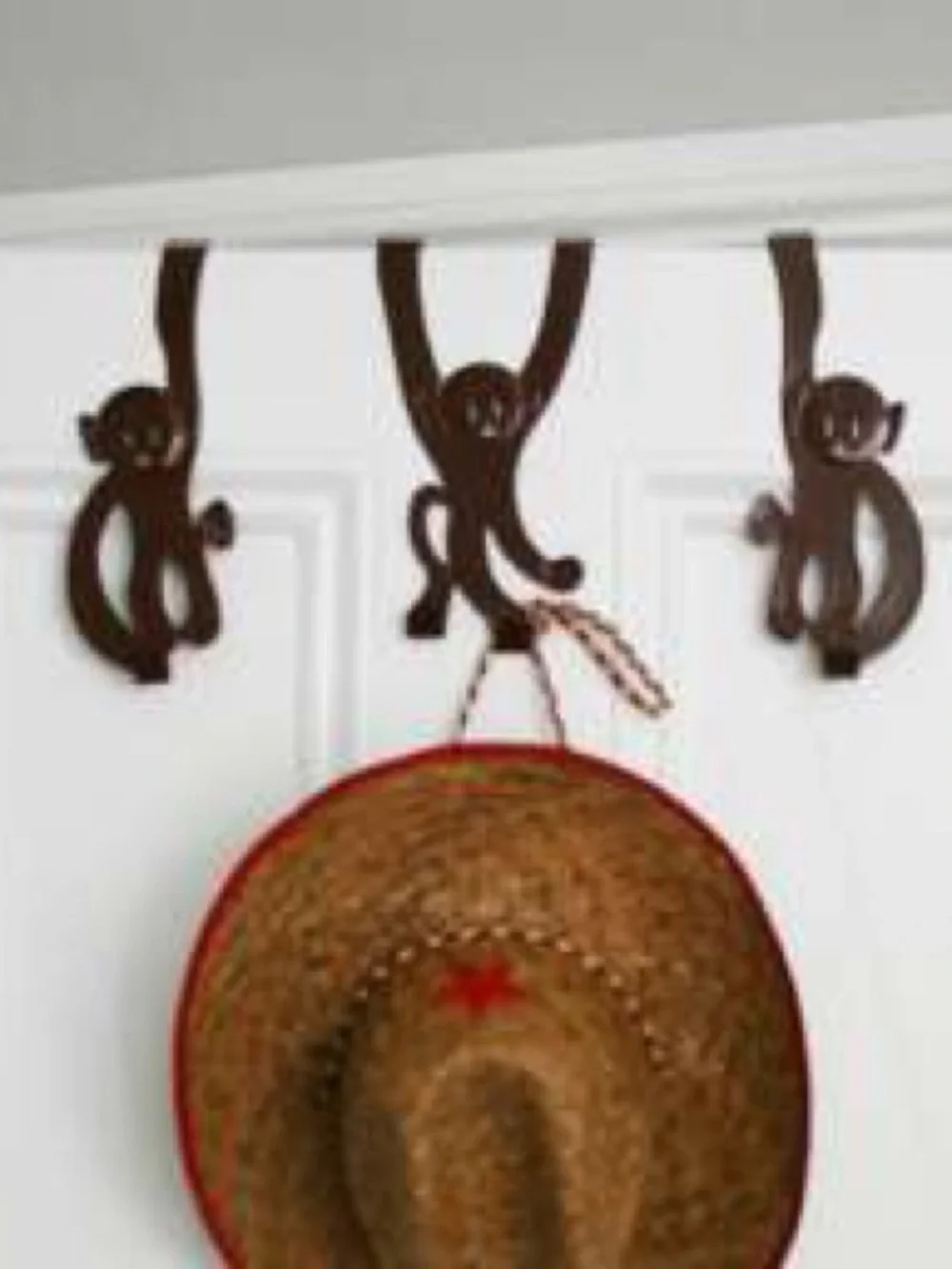 A set of 3 whimsical brown metal monkey over-the-door hooks